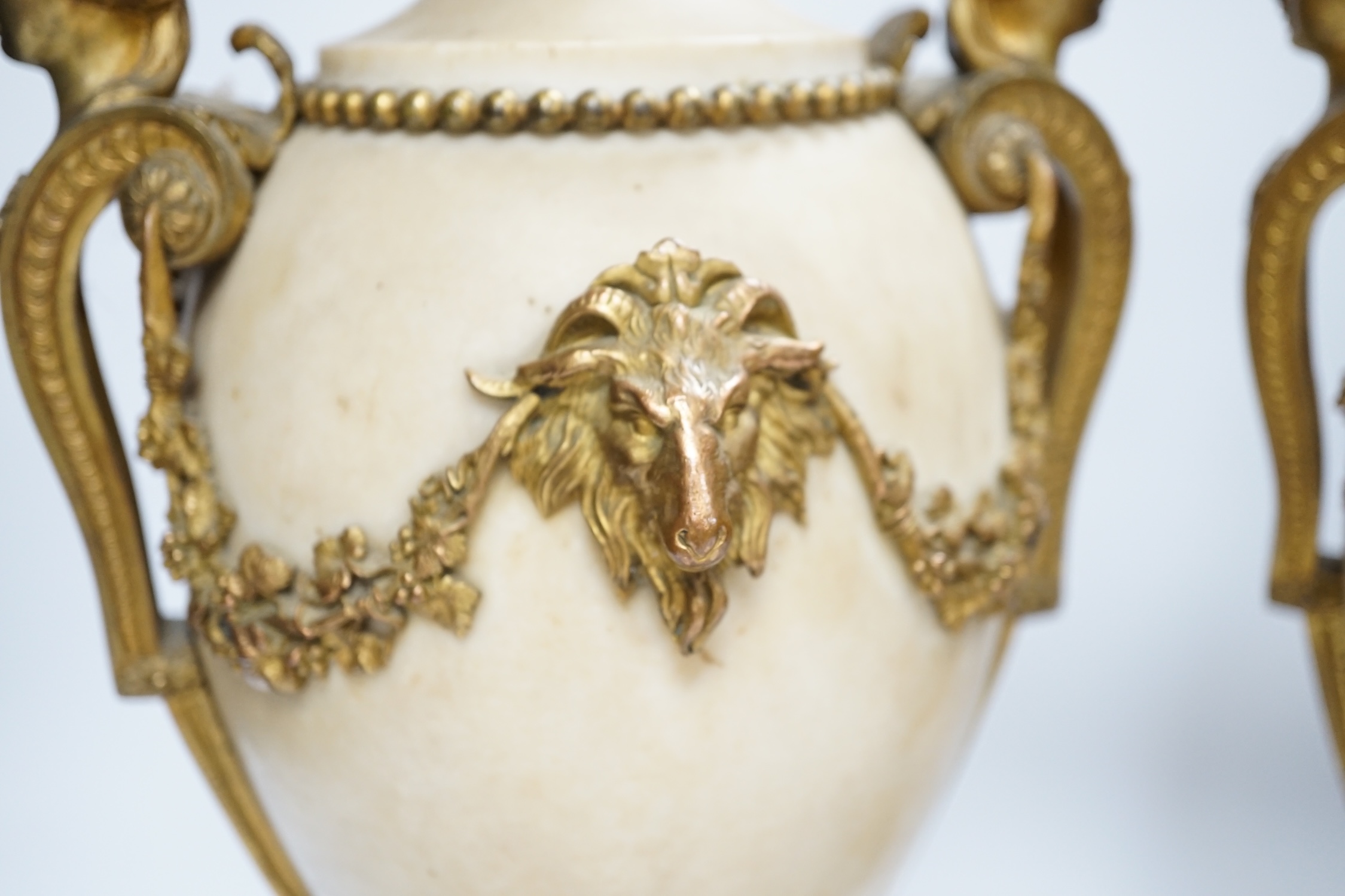 A pair of Adam style gilt metal mounted alabaster urns, 42cm high